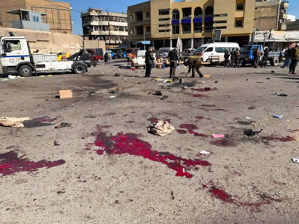 Miembros de las fuerzas de seguridad trabajan en la escena de un ataque suicida en un mercado de ropa de segunda mano, en Bagdad, Irak, el 21 de enero de 2021. (AP)