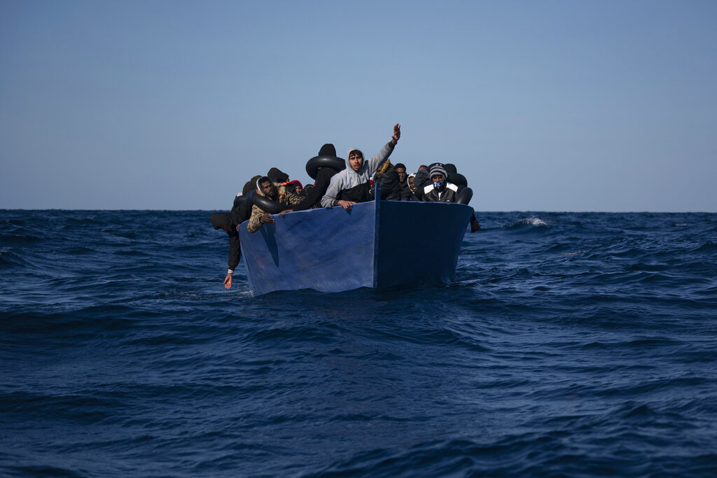 Migrantes, la mayoría de Eritrea, reaccionan mientras esperan ser asistidos por trabajadores del organismo español Open Arms, después de huir de Libia a bordo de un bote de madera en el mar Mediterráneo, a unos 180 kilómetros (110 millas) al norte de Libia, el sábado 2 de enero de 2021. (AP)